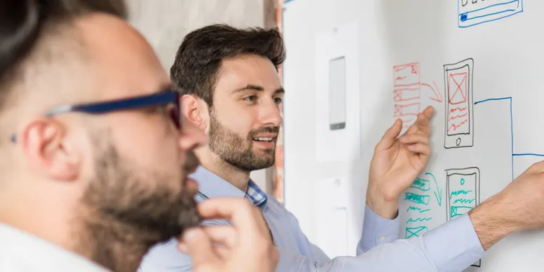 Two people working on a whiteboard