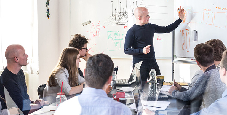 Group learning from man at whiteboard